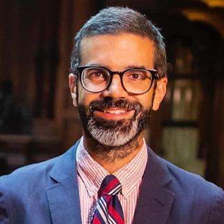 A man in glasses and suit and tie
